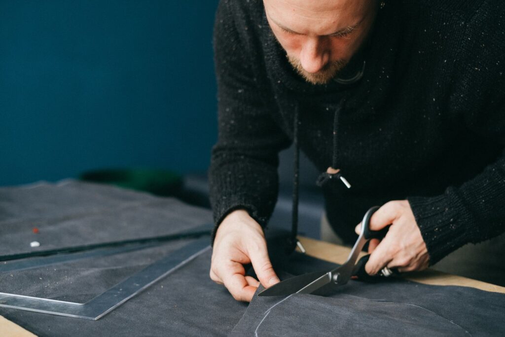 Pattern maker cutting fabric in a garment workshop