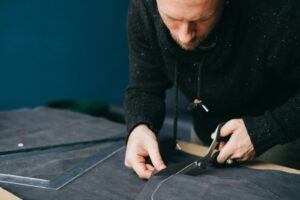 Pattern maker cutting fabric in a garment workshop
