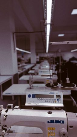 Rows of industrial sewing machines in a garment factory